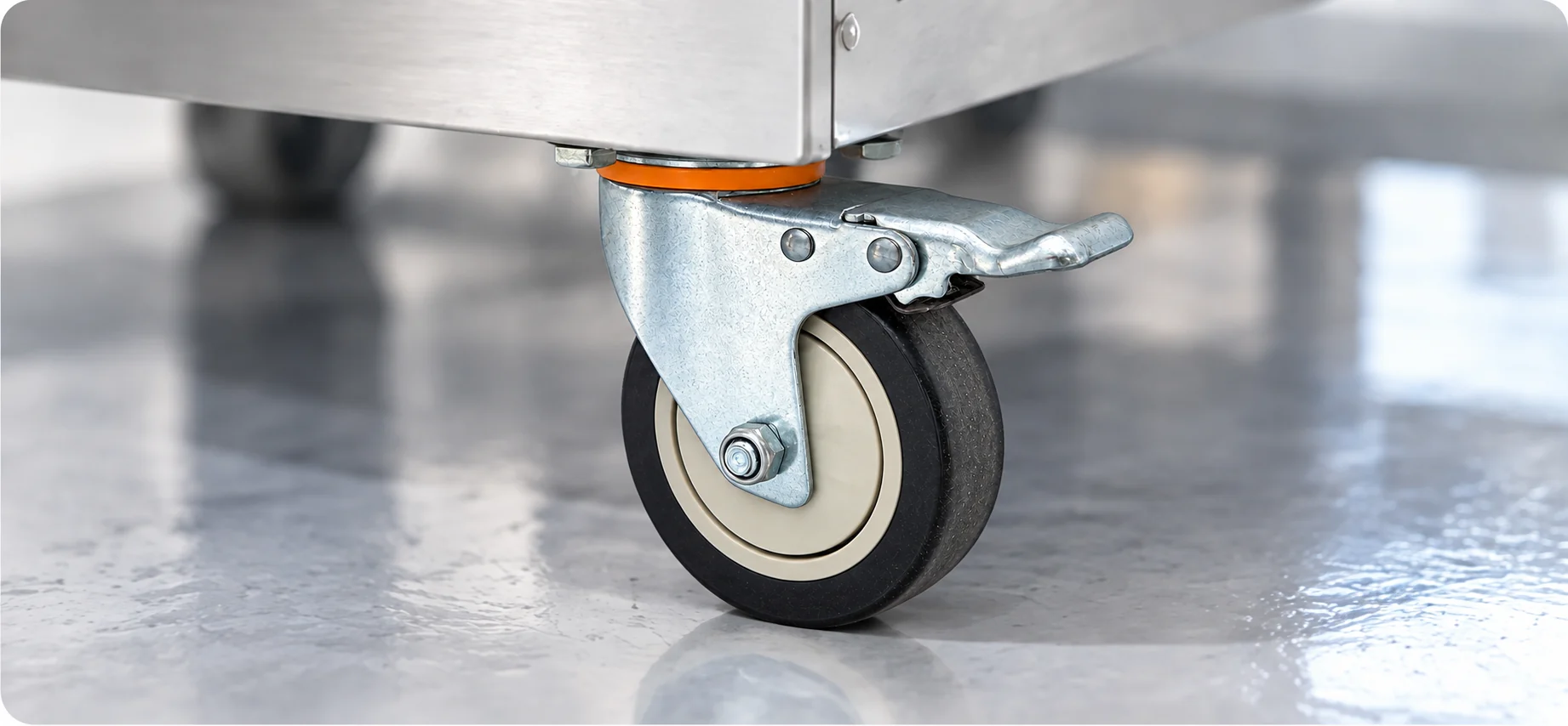 Close-up of a swivel caster and its locking mechanism beneath the machine